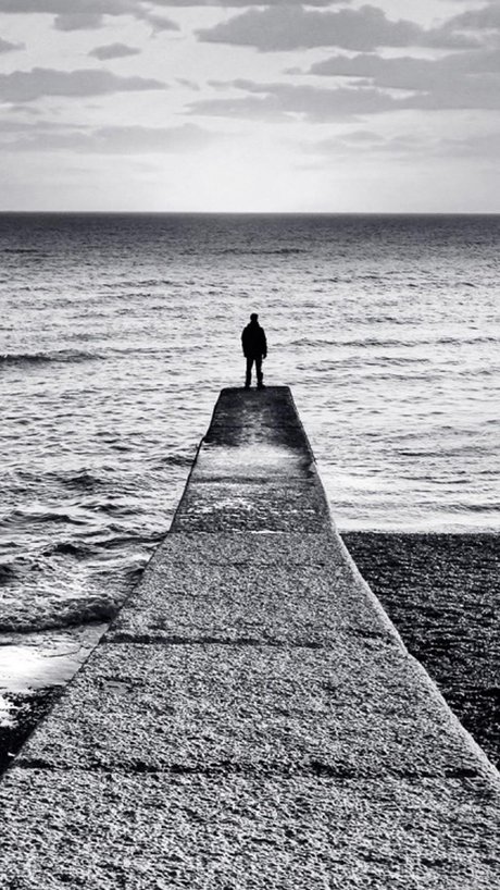 夕阳下一个人看海的孤独背影
