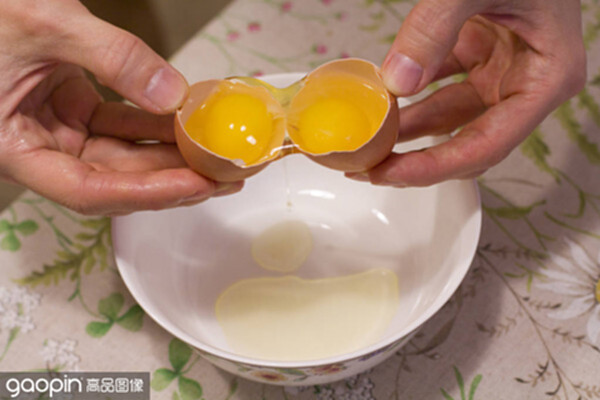 two yolks in one egg. 2 in 1. womens hands open a unique egg wi