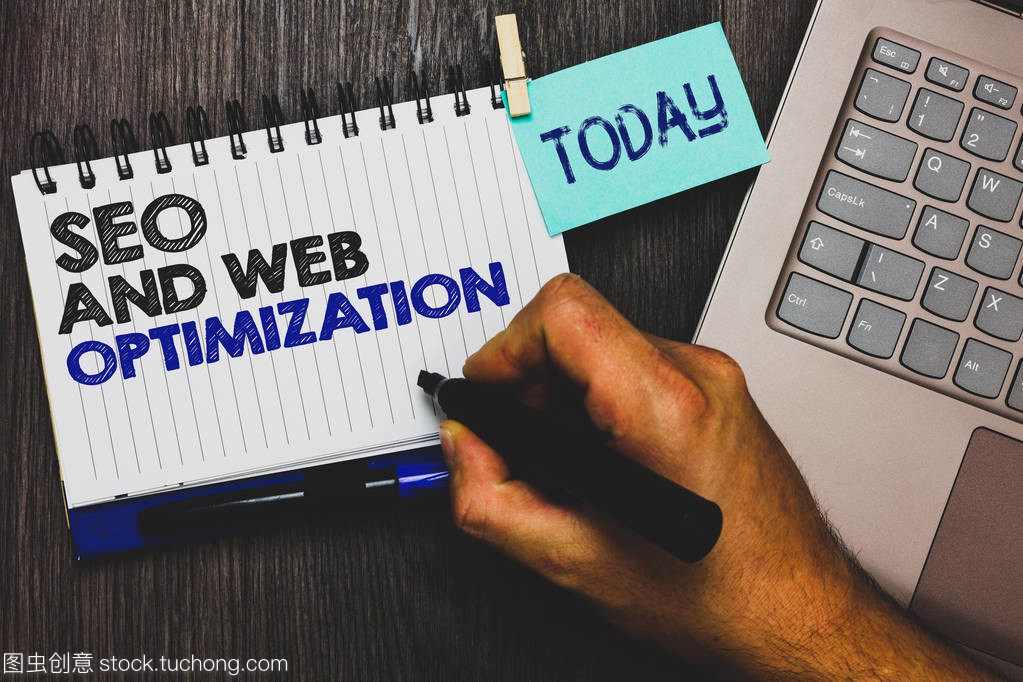 Word writing text Seo And Web Optimization. Business concept for Search Engine Keywording Marketing Strategies Paperclip grip sticky note with text hand hold pen computer on wooden desk